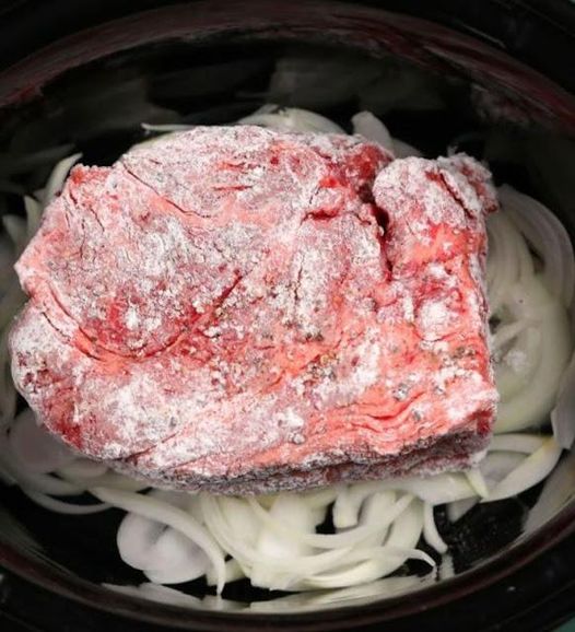 Put floured beef over a bed of onions in a slow cooker for this remarkable meal